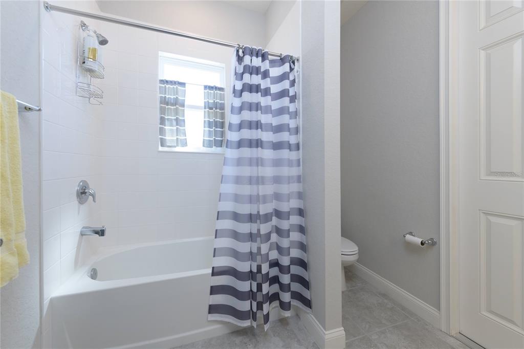 4444 Devinshire Fields Loop Plant City, FL 33567 - Photo 25 of 38 a bathroom with a bathtub and shower