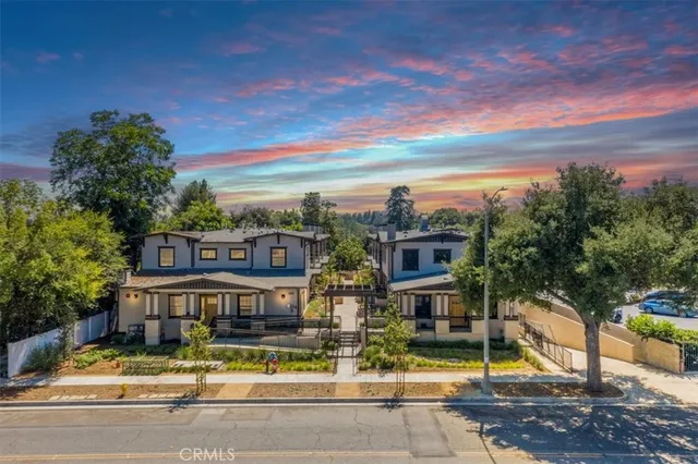 front view of house with a yard and large trees