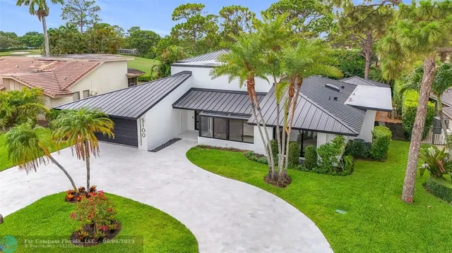a aerial view of a house next to a yard