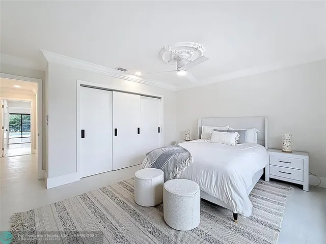 a spacious bedroom with a large bed and a chandelier