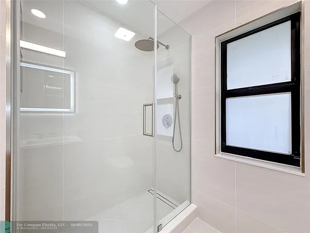 a bathroom with a double vanity sink mirror and shower