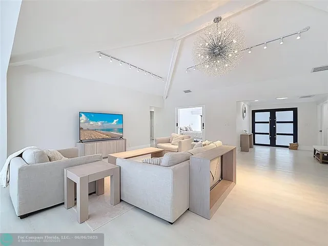 a large kitchen with kitchen island a large counter space a sink appliances and living room view