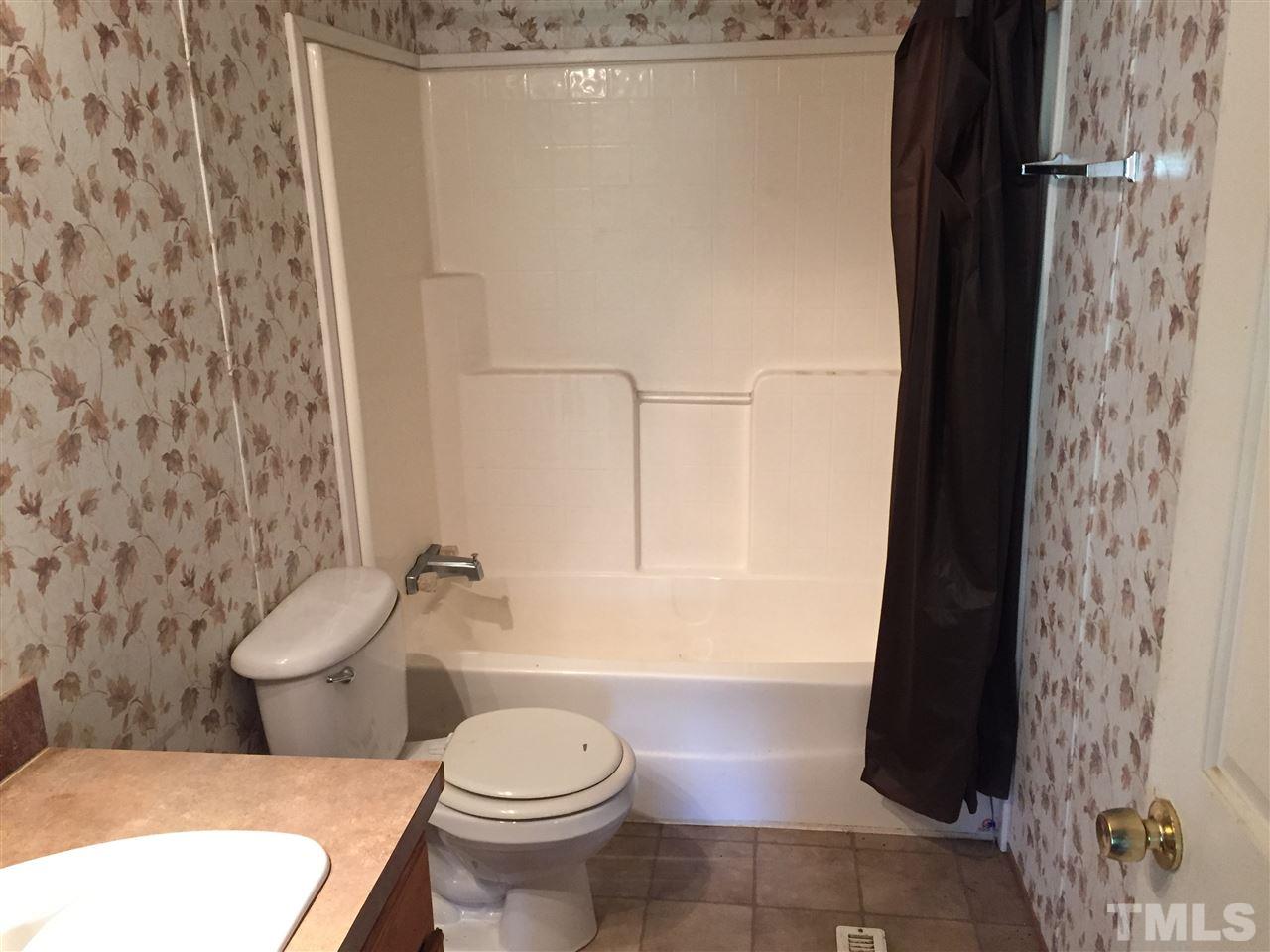 16 Trevor Kirk Road Timberlake, NC 27583 - Photo 11 of 12 a white toilet sitting next to a shower curtain