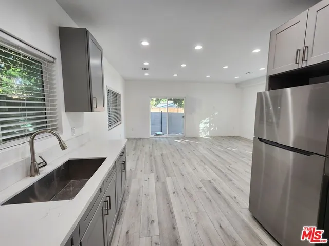 a kitchen with a refrigerator sink and wooden cabinets