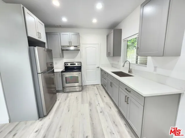 a kitchen with kitchen island a sink a counter top space stainless steel appliances and cabinets