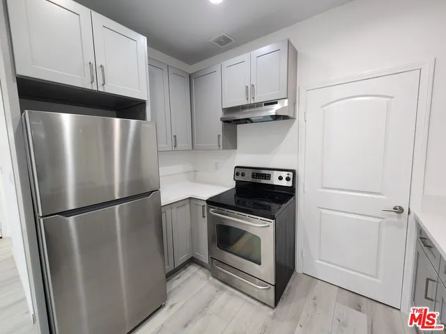 a kitchen with a refrigerator sink and cabinets