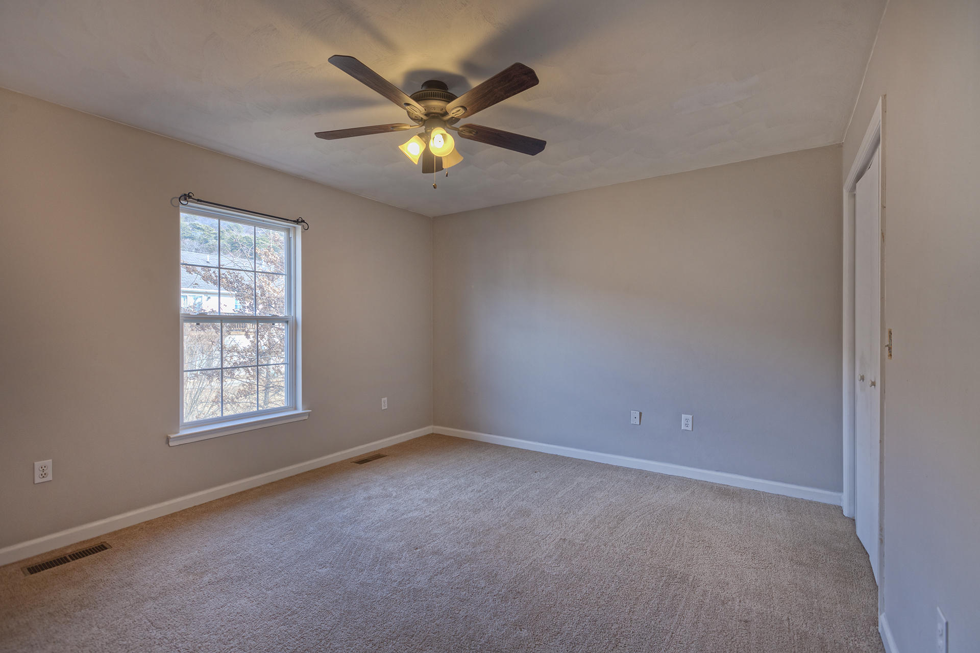 4754 West Westvale Road Northeast Roanoke, VA 24019 - Photo 6 of 22 an empty room with windows and fan