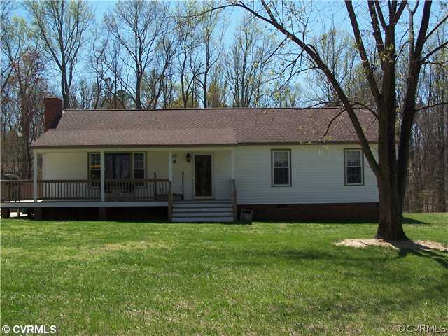 a front view of a house with a garden and yard