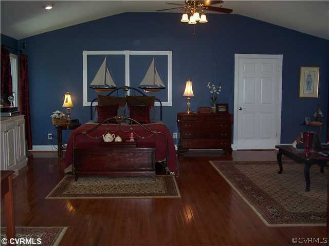 14801 River Road Chesterfield, VA 23838 - Photo 7 of 12 a bedroom with a bed and a chandelier