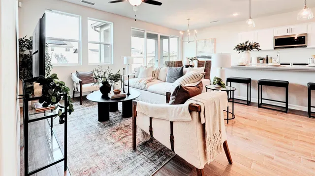 a living room with furniture a flat screen tv and a table