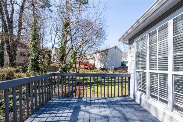 a view of a hallway with wooden floor and a bathroom
