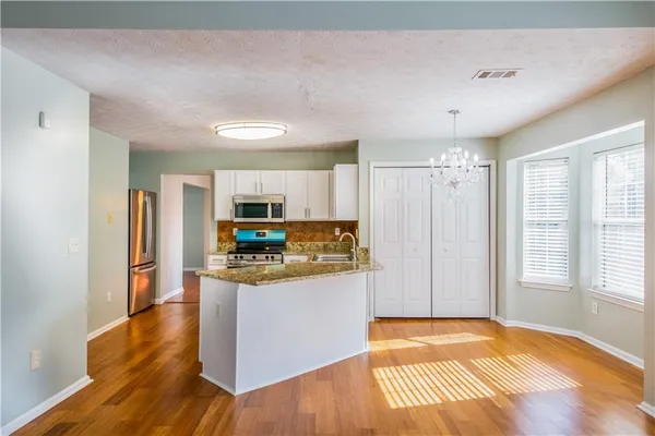 a kitchen with stainless steel appliances granite countertop a refrigerator and a stove top oven