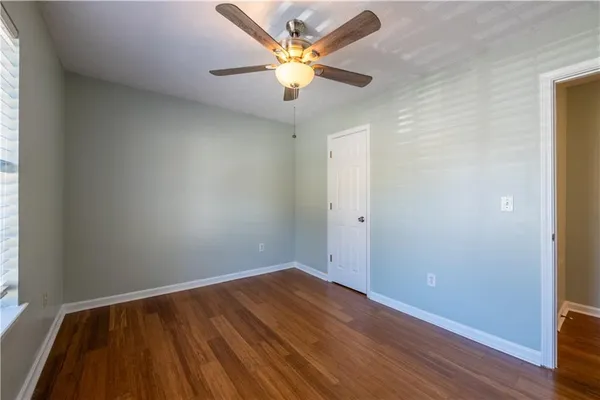 a view of a room with wooden floor and a ceiling fan