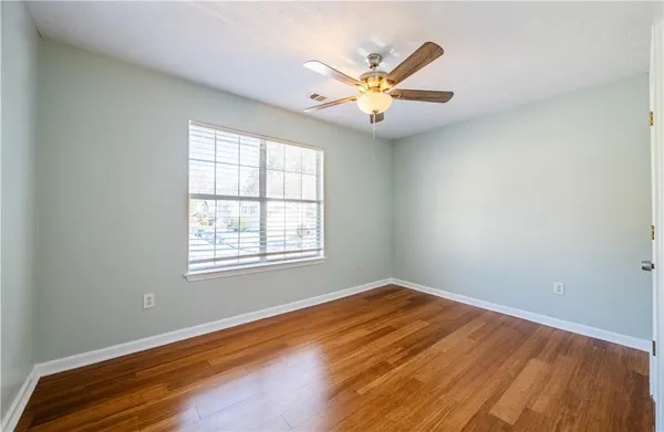 a view of a hallway with wooden floor and closet