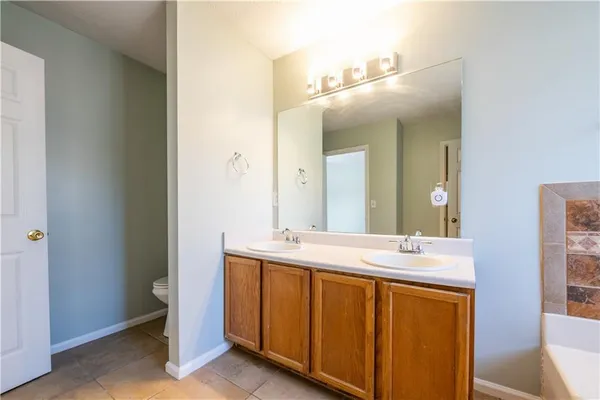 a kitchen with kitchen island granite countertop a sink cabinets and stainless steel appliances