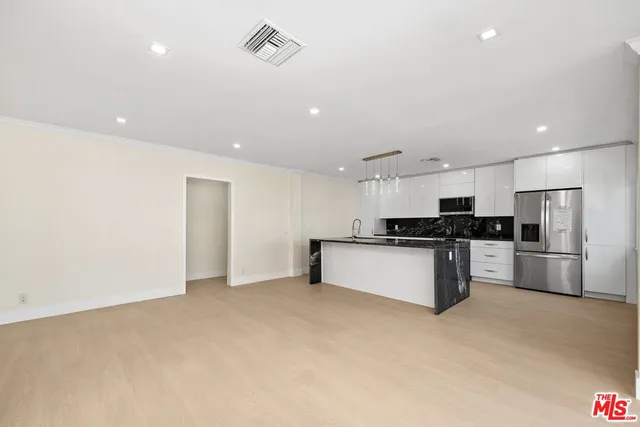 a large kitchen with stainless steel appliances kitchen island a large counter top and stainless steel appliances