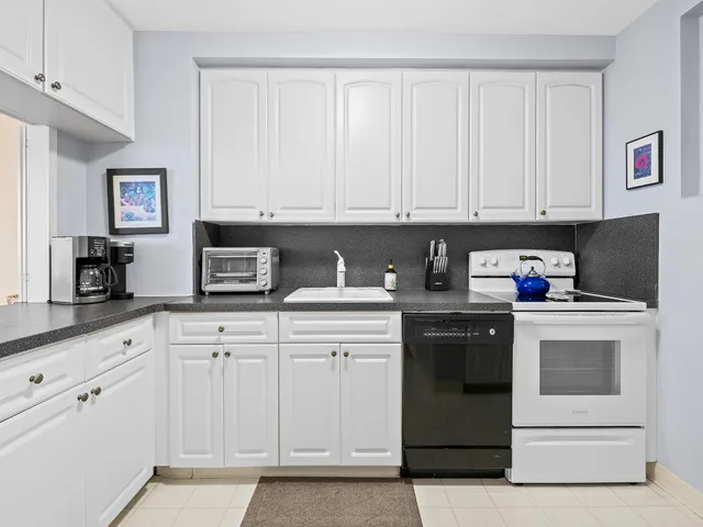 a kitchen with white cabinets and white appliances