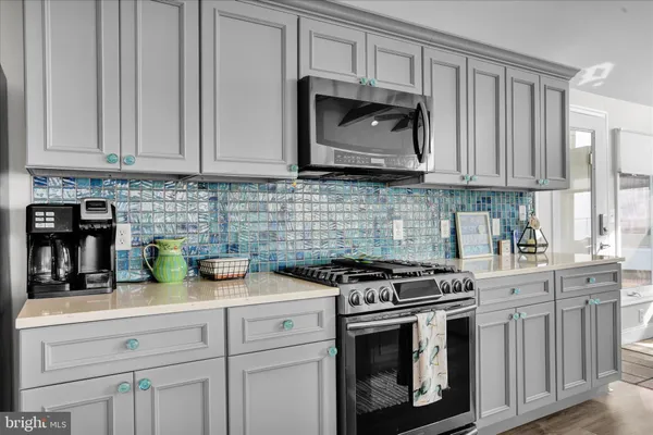 a kitchen with white cabinets and appliances
