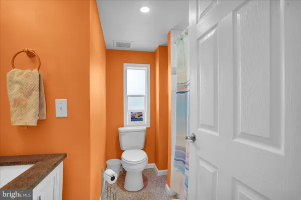 a bathroom with a toilet a sink and shower curtain