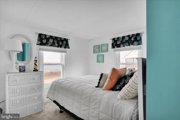 a bedroom with a bed a window and dresser