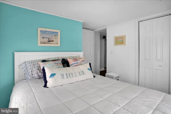 a bedroom with a bed and painting on the wall