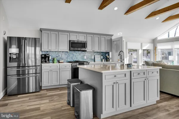 a kitchen with appliances a sink cabinets and a window