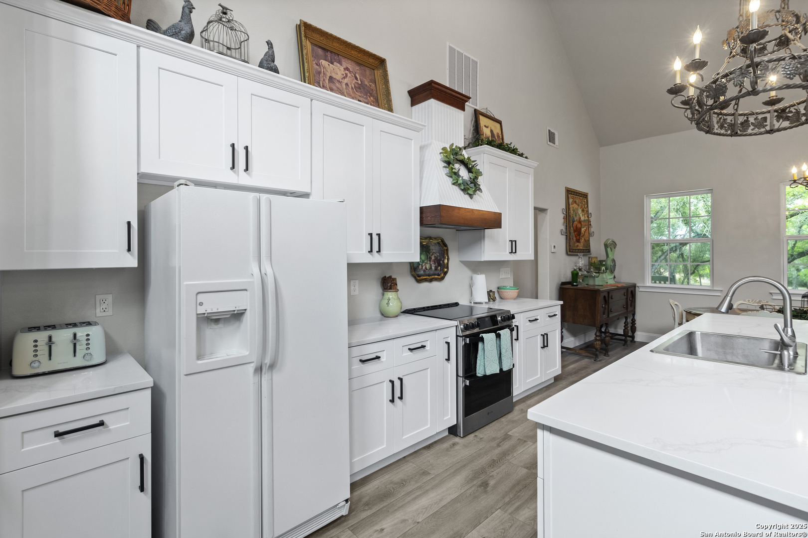 792 Alamo Beach Road Pipe Creek, TX 78063 - Photo 11 of 70 a kitchen with white cabinets and white appliances