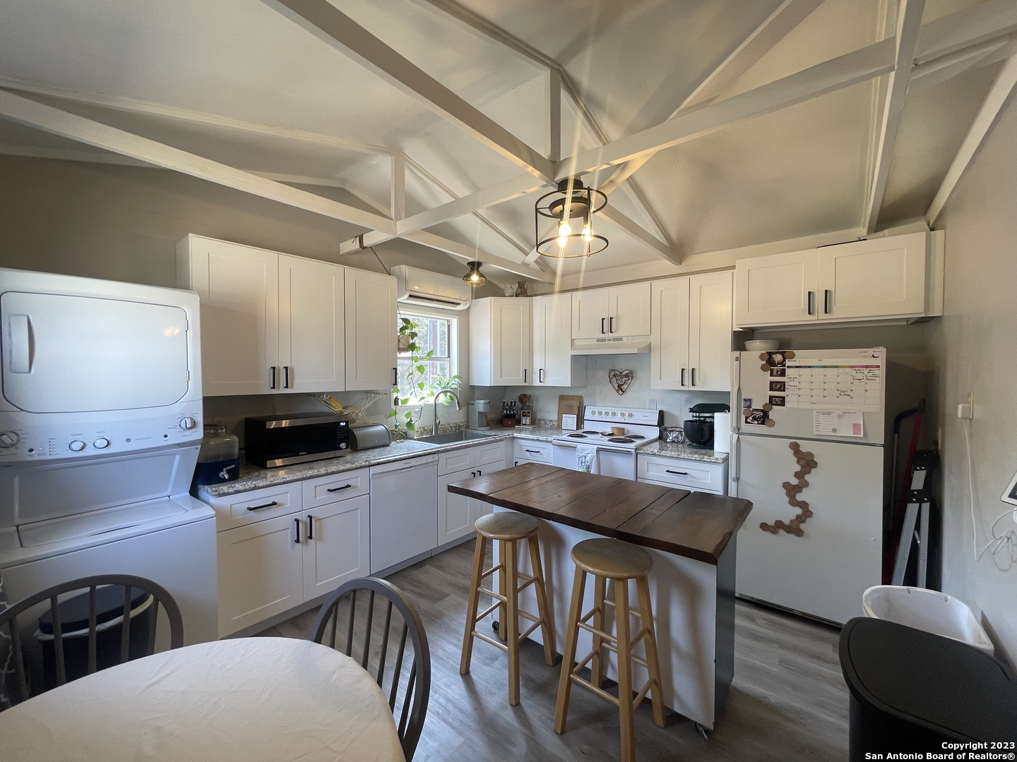 792 Alamo Beach Road Pipe Creek, TX 78063 - Photo 49 of 70 a kitchen with sink a stove a refrigerator and chairs
