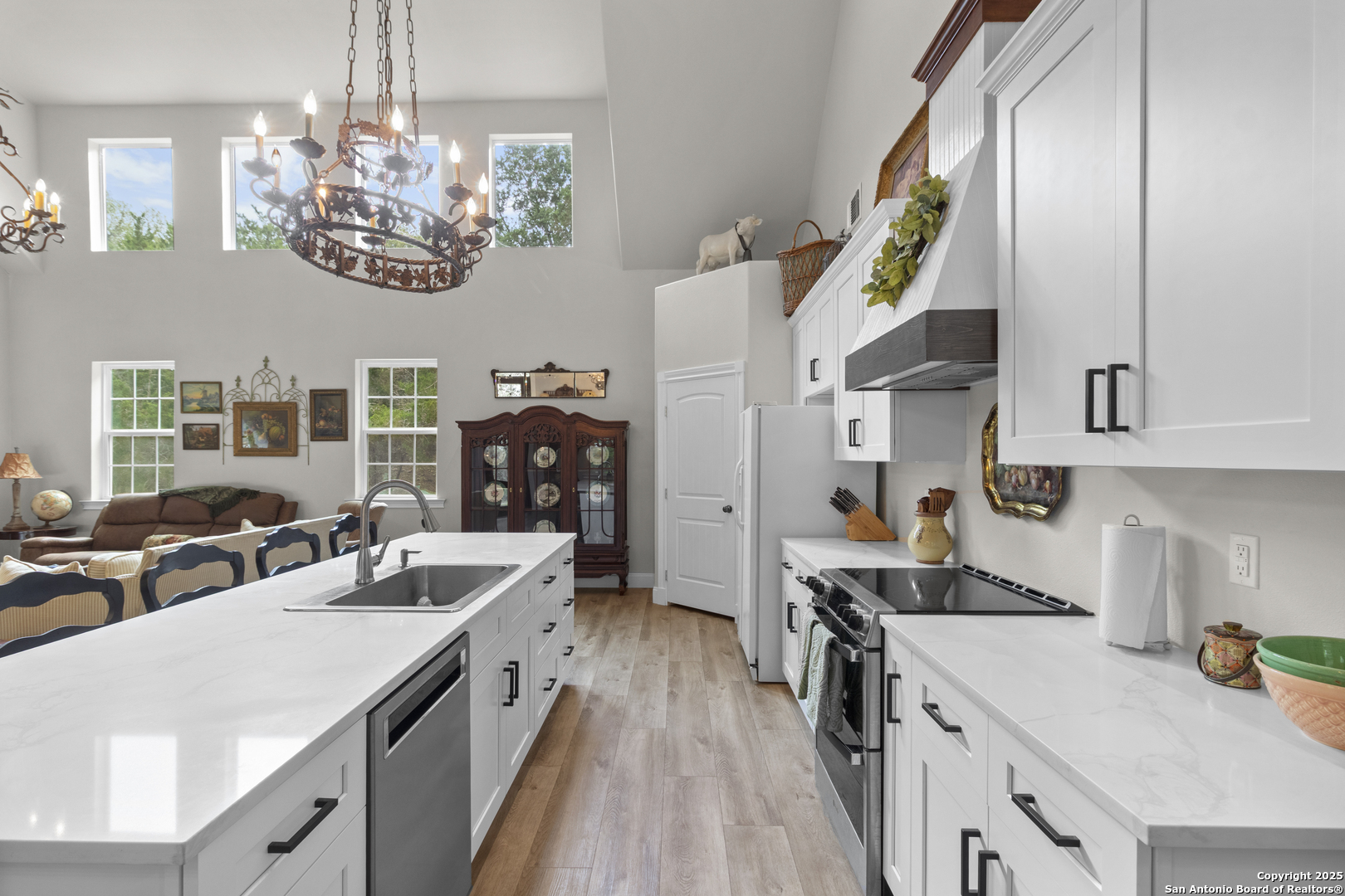 792 Alamo Beach Road Pipe Creek, TX 78063 - Photo 7 of 70 a kitchen with a sink dishwasher a stove and a dining table with wooden floor