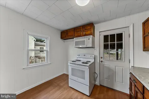 a kitchen with stainless steel appliances a stove a microwave and a window