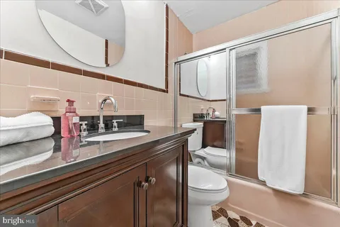 a bathroom with a sink a toilet and a mirror