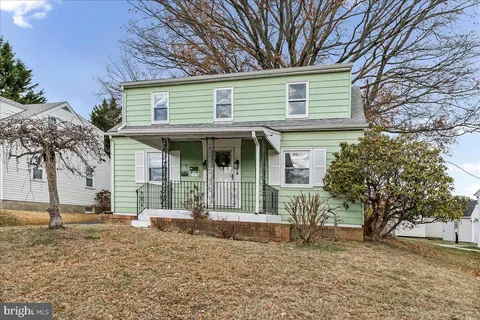 a front view of a house with a tree