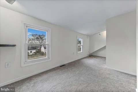 an empty room with windows and closet