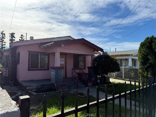 a view of a house with wooden fence and trees