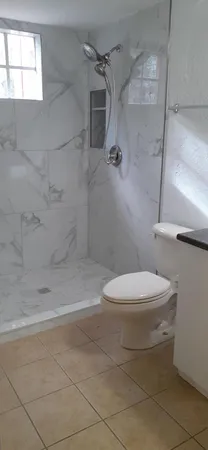 a bathroom with a granite countertop sink a toilet and bathtub