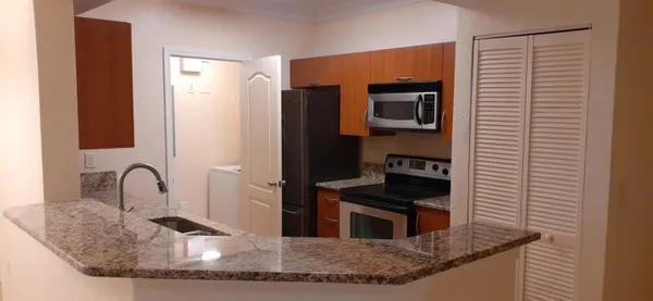 a kitchen with granite countertop a sink and a stove