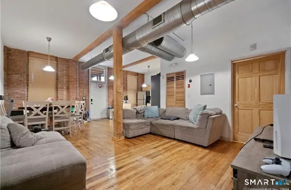 a living room with furniture and a wooden floor