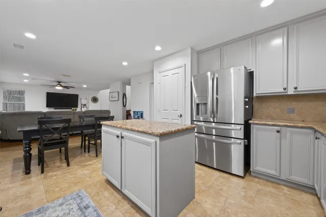 a kitchen with kitchen island white cabinets and stainless steel appliances