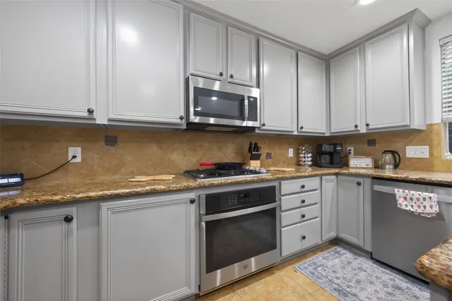 a kitchen with granite countertop cabinets stainless steel appliances and a sink