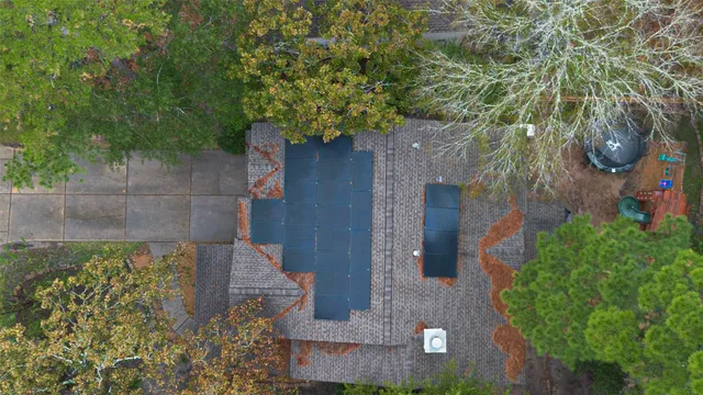 an aerial view of residential houses with outdoor space and trees