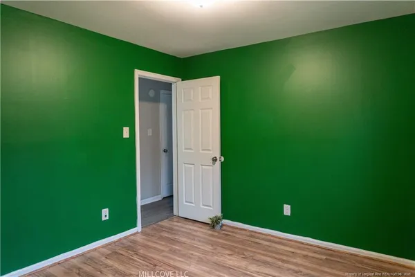 a view of an empty room with window and closet