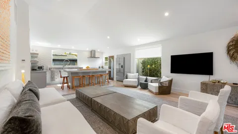 a living room with furniture a flat screen tv and a large window