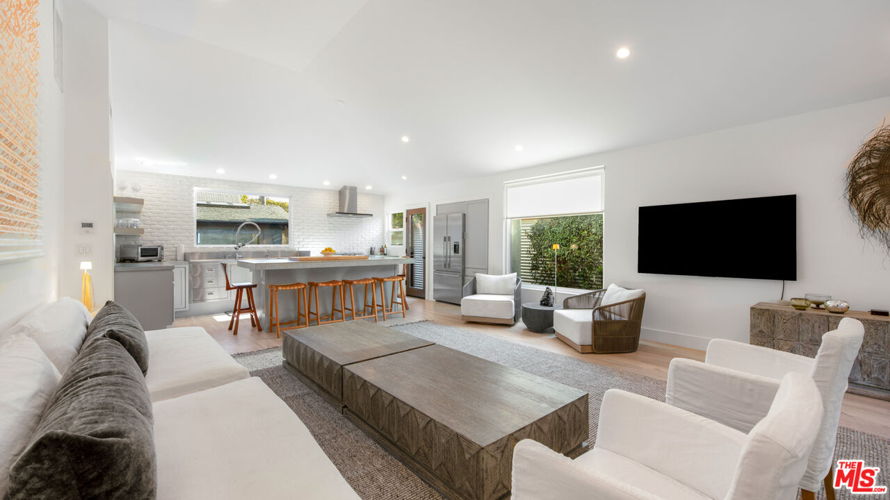 a living room with furniture a flat screen tv and a large window