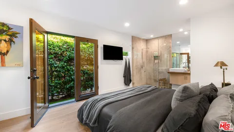 a bedroom with a bed and a large window