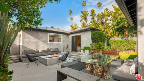a view of backyard with outdoor seating and plants