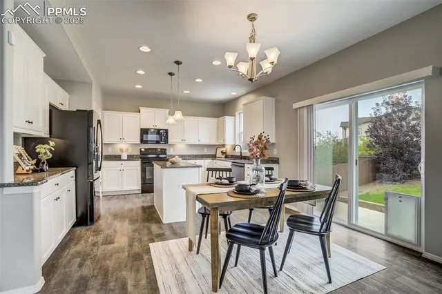 a kitchen with kitchen island granite countertop stainless steel appliances a table and chairs in it