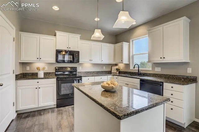 a kitchen with stainless steel appliances granite countertop a sink stove and cabinets