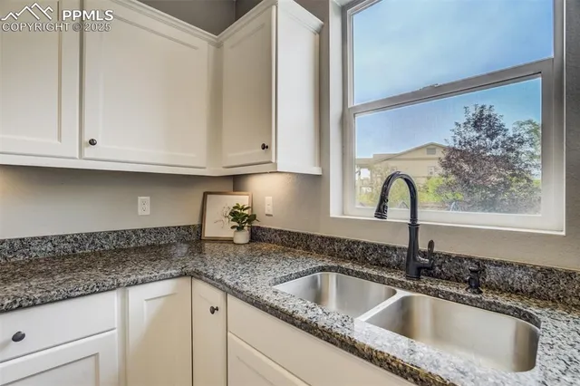 a kitchen with granite countertop a sink and cabinets