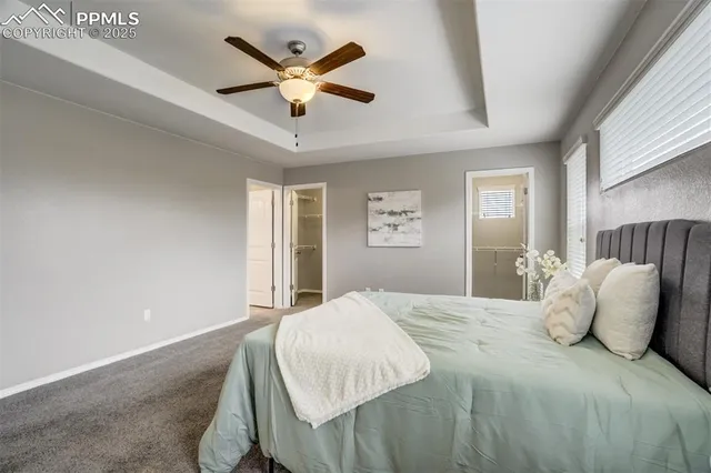 a bedroom with a large bed and a ceiling fan