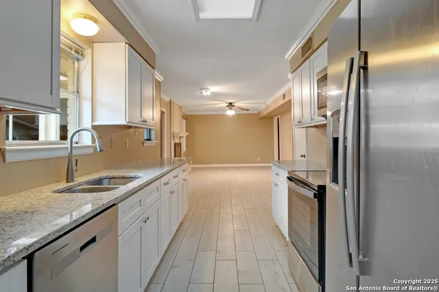 a bathroom with a granite countertop double vanity and a mirror